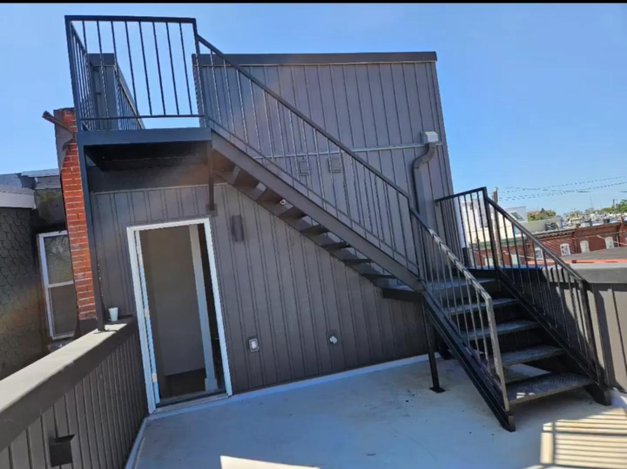 Steel rooftop egress stair with landing and vertical picket railing