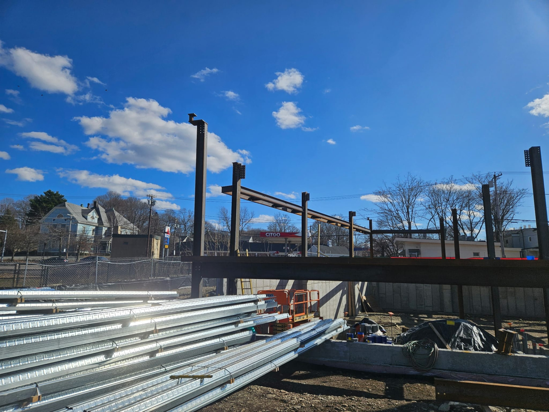 Steel columns and beams with metal floor deck staged alongside