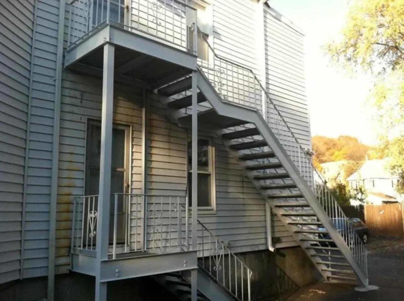 Galvanized steel porch stair and landing on a wood-frame home