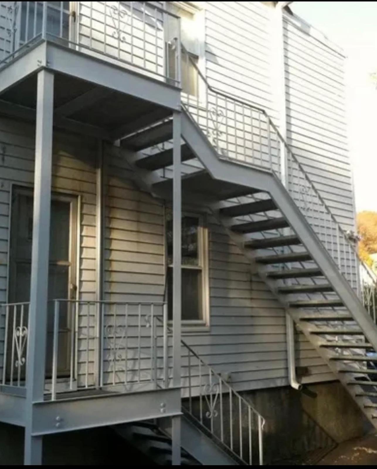 Steel egress stair with landings on a three-family house
