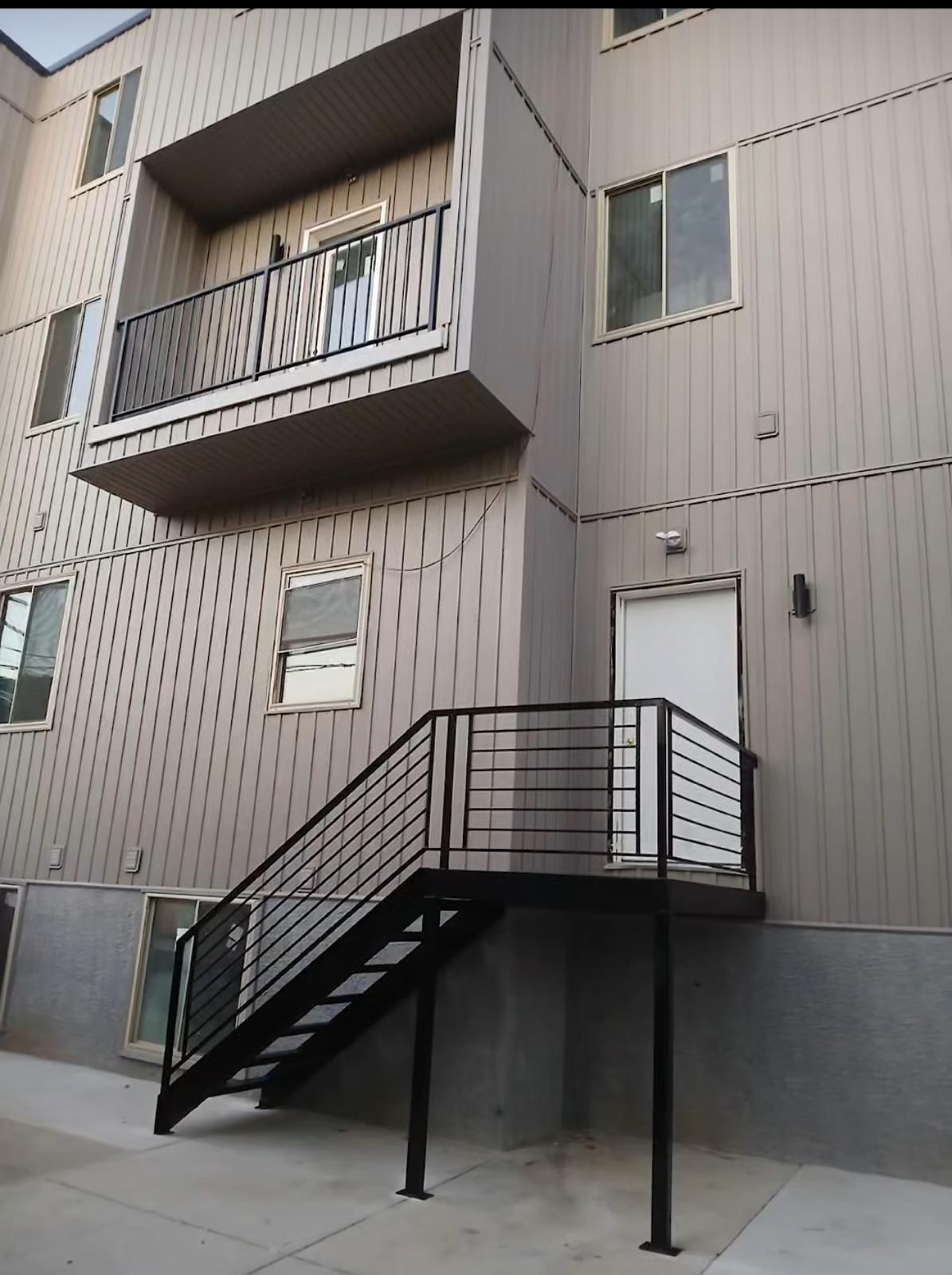 Black steel stair and landing at a rear apartment entrance