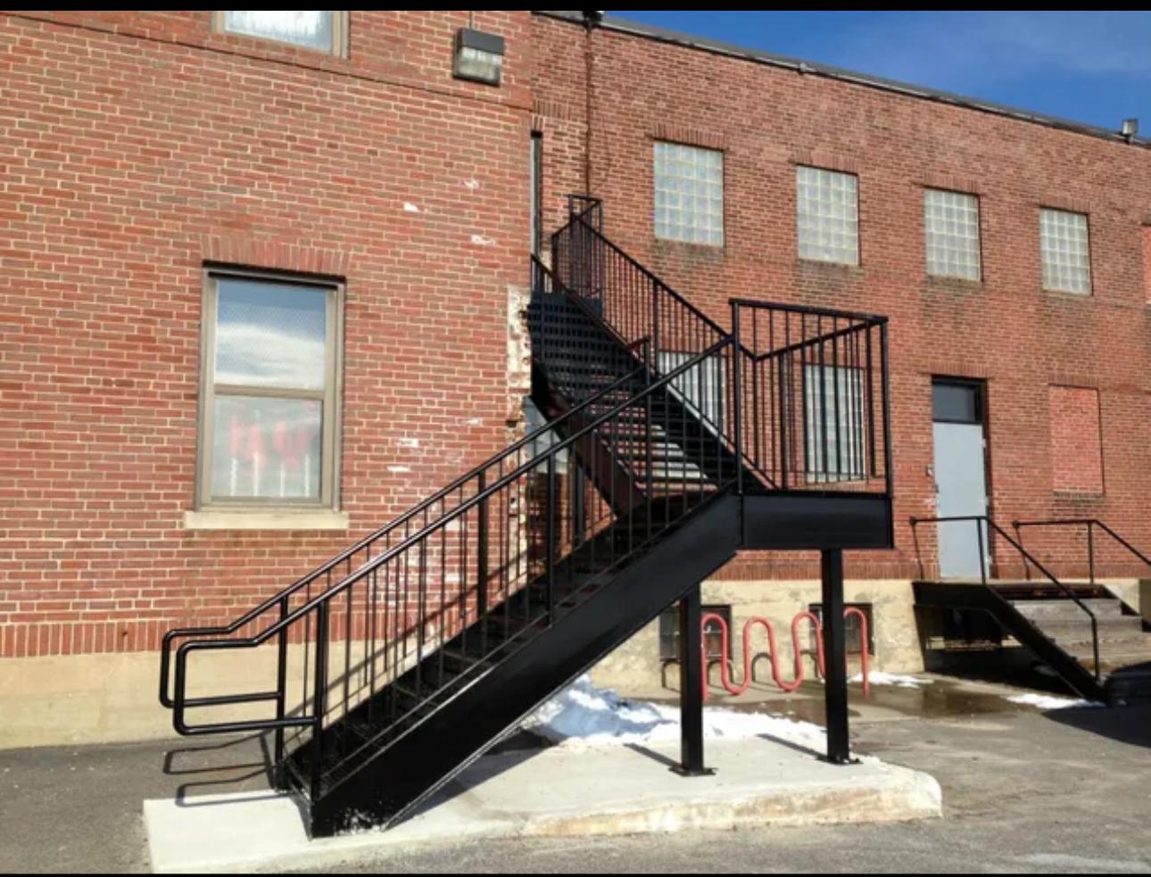 Black steel commercial egress stair on a brick building