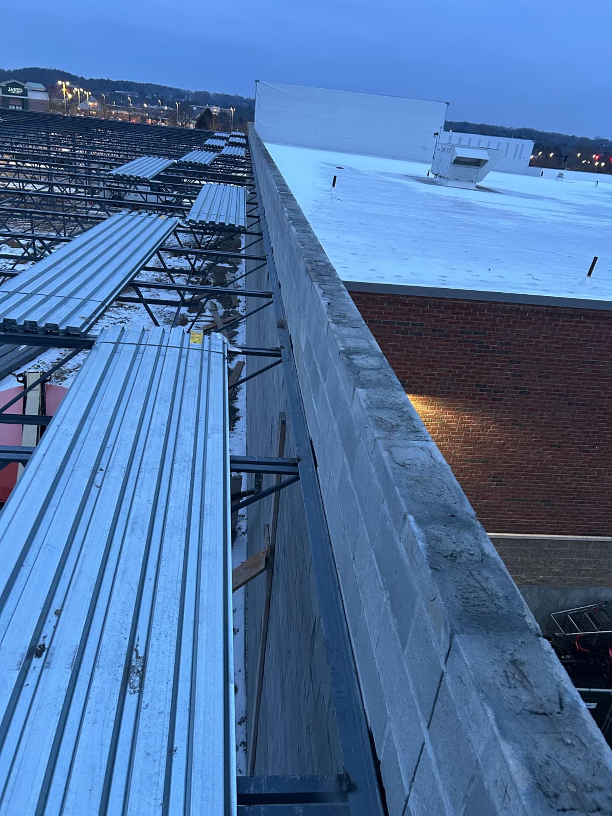 Bundles of metal roof deck staged on steel framing